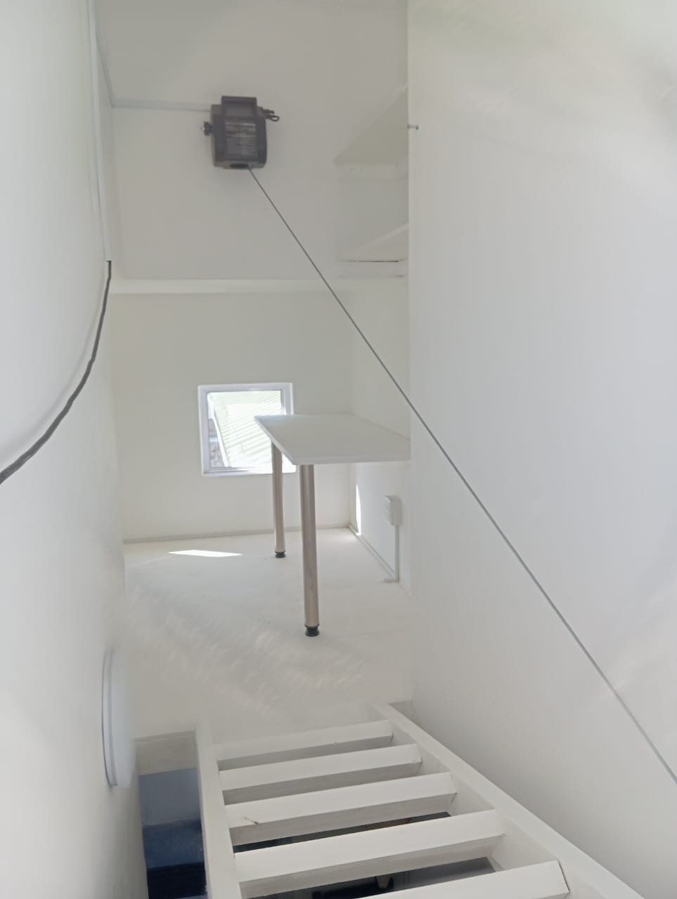 Wall-mounted control point to raise and lower the retractable loft ladder