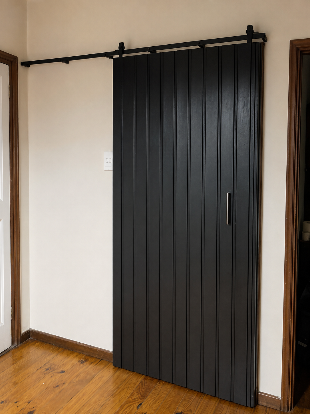 Finished black sliding wooden door installation